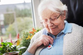 Foto: Alte Frau mit Notknopf